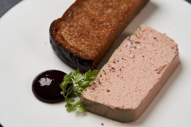 Foto geröstetes brot mit pastete in weißem teller mit kopierraum, nahaufnahme.