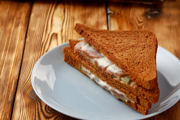 Geröstetes Roggensandwich in Platte auf Holztisch nah oben