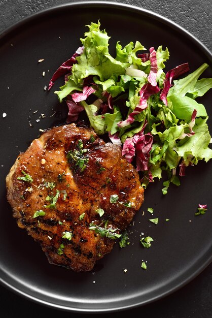 Foto geröstetes schweinesteak mit gemüsesalat