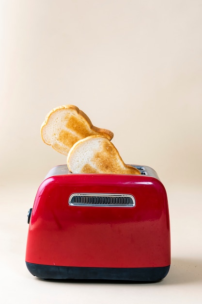 Geröstetes Toastbrot, das aus einem roten Toaster auftaucht