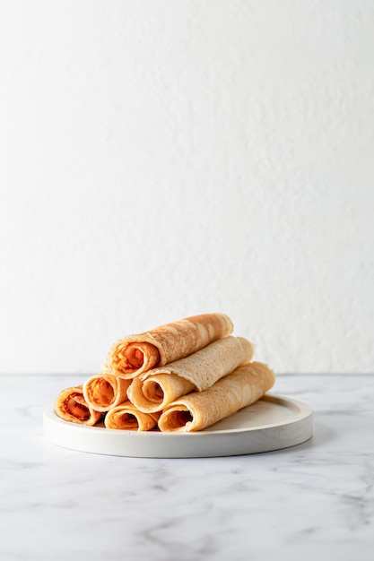 Gerollte Crêpes oder dünne Pfannkuchen auf weißem Marmorhintergrund mit Kopierraum Maslenitsa oder Pancake Day traditionelles Food-Konzept