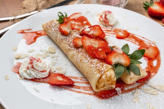 Gerollte Crepes oder Pfannkuchen mit frisch gehackten Erdbeeren