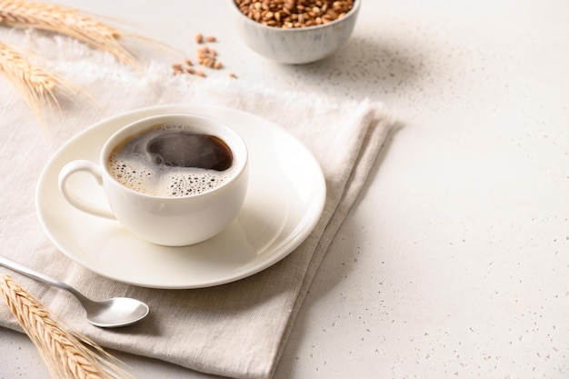 Gerstenkaffee in weißer Tasse und Gerstenohren auf weißem Hintergrund