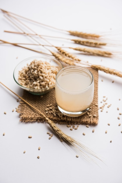 Gerstenwasser im Glas mit rohem und gekochtem Graupen oder Samen. selektiver Fokus