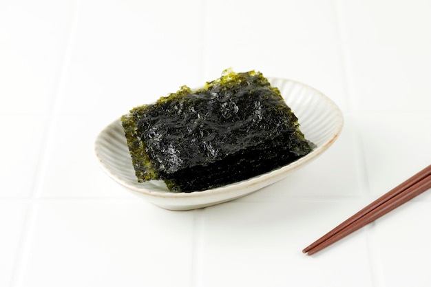 Gesalzenes Nori-Laver-Blatt auf weißem Teller Beliebt in Japan und Korea für Sushi und Kimbap