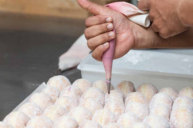 Geschäft Bäckerei Nahaufnahme Hand Arbeit frisch Donut Marmelade Hintergrund