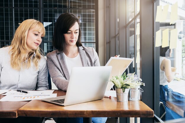 Geschäft, das mit Frau und Freund mit Laptop arbeitet