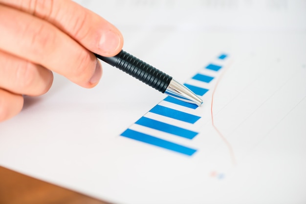 Geschäft - Geschäftsmann, der mit Diagramm und Diagramm arbeitet