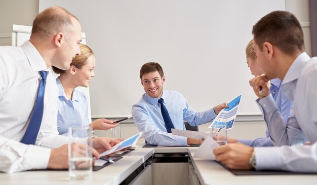 Geschäft, Menschen und Teamwork-Konzept - Gruppe lächelnder Geschäftsleute, die sich im Büro treffen