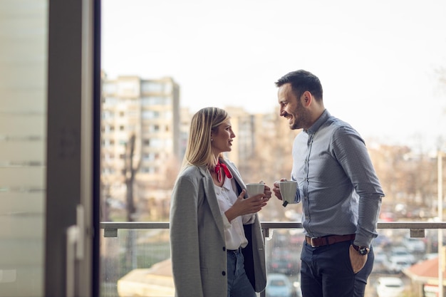 Geschäftliches und frische Luft in der Kaffeepause auf dem Balkon vor dem Büro.