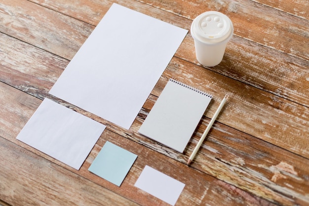 Geschäfts-, Bildungs- und Objektkonzept - Nahaufnahme von Notizbuch, Kaffeetasse, Bleistift und Papieren auf dem Tisch