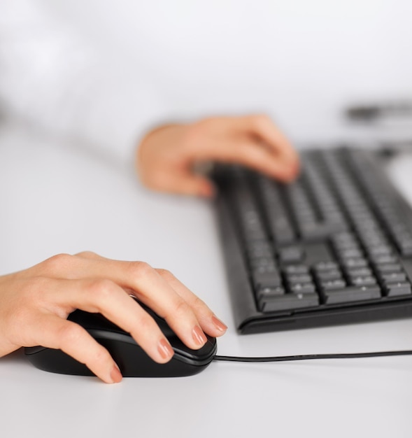 Geschäfts-, Büro-, Schul- und Bildungskonzept - Frauenhände mit Tastatur und Maus