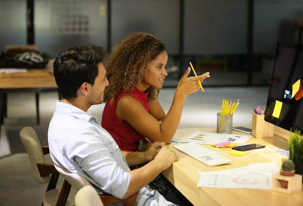 Geschäfts-Kollegen, die am Schreibtisch im Büro arbeiten