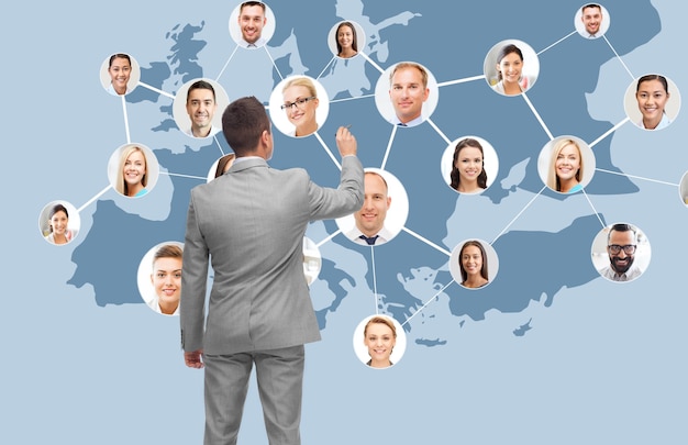 Geschäfts-, Menschen-, Kommunikations-, Kooperations- und Technologiekonzept - Geschäftsmann mit Markierung auf virtuellem Bildschirm mit Kontaktsymbolen und Europakarte auf blauem Hintergrund