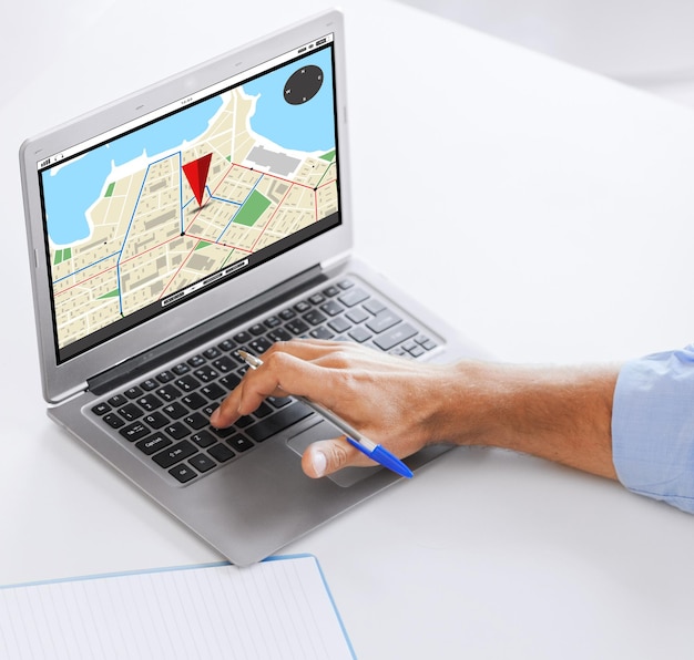 Foto geschäfts-, navigations-, technologie- und personenkonzept - nahaufnahme eines geschäftsmannes mit gps-navigatorkarte auf dem laptop-bildschirm, der im büro arbeitet