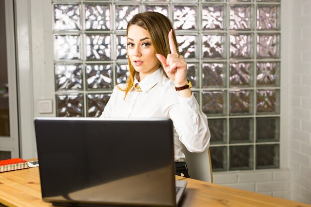 Geschäfts-, Personen- und Arbeitsideenkonzept - Geschäftsfrau, die Finger im Büro zeigt