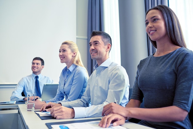 Geschäfts-, Personen- und Konferenzkonzept - lächelndes Geschäftsteamtreffen zur Präsentation im Büro