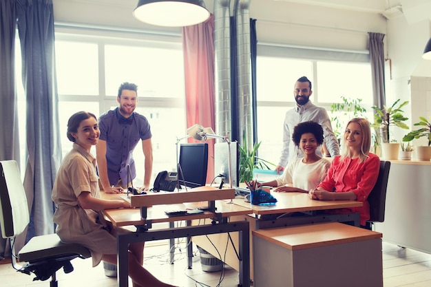 geschäfts-, start- und personenkonzept - glückliches kreatives team im büro