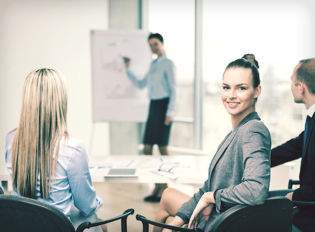 Foto geschäfts- und bürokonzept - lächelnde geschäftsfrau mit team im büro