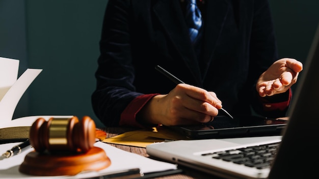 Geschäfts- und Rechtsanwälte diskutieren Vertragspapiere mit Messingwaage auf dem Schreibtisch im Büro Rechtliche Dienstleistungen beraten Justiz- und Rechtskonzeptbild mit Filmkörnungseffekt