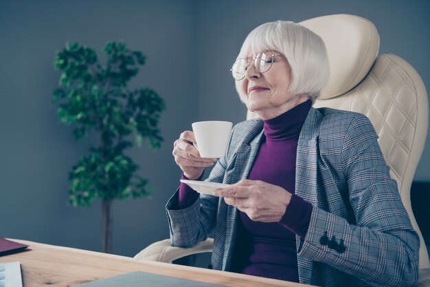 Geschäftsdame am Schreibtisch trinkt Kaffee