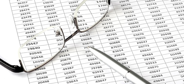 Geschäftsdiagramm, Stift und Gläser auf dem weißen Hintergrund