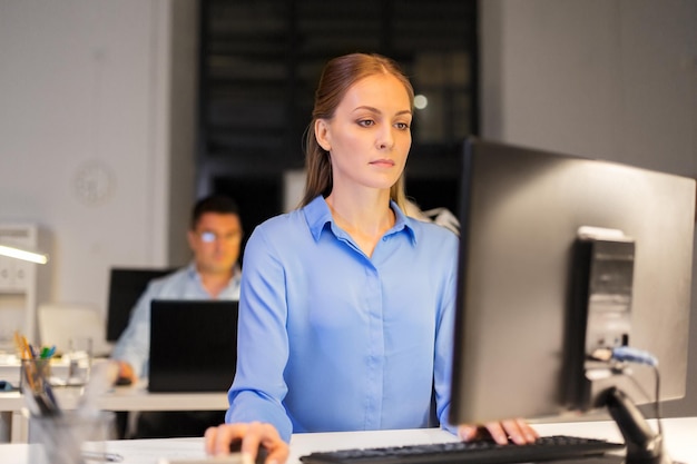 Foto geschäftsfrau am computer, die nachts im büro arbeitet