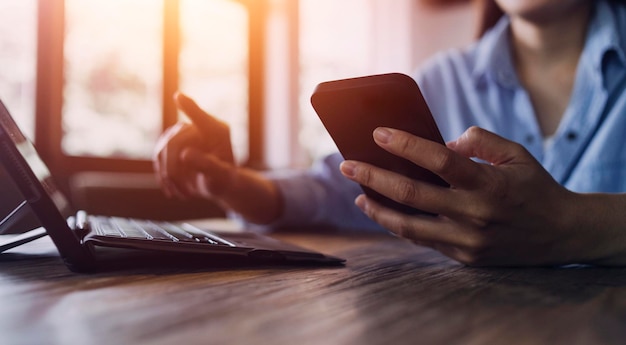 Geschäftsfrau arbeitet mit Laptop-Computer, Tablet und Smartphone im modernen Büro mit virtuellem Symboldiagramm im Modernoffice im Morgenlicht