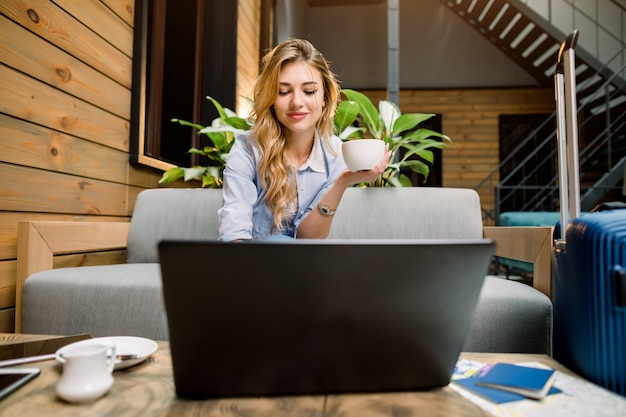 Geschäftsfrau auf der Reise, die an Laptop in der Lounge arbeitet, die Monitor betrachtet.