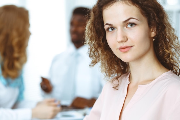 Geschäftsfrau bei der Besprechung im Büro, weiß gefärbt. Multiethnische Gruppe von Geschäftsleuten