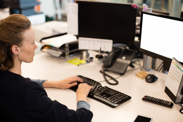 Geschäftsfrau, die am Computer im Büro arbeitet