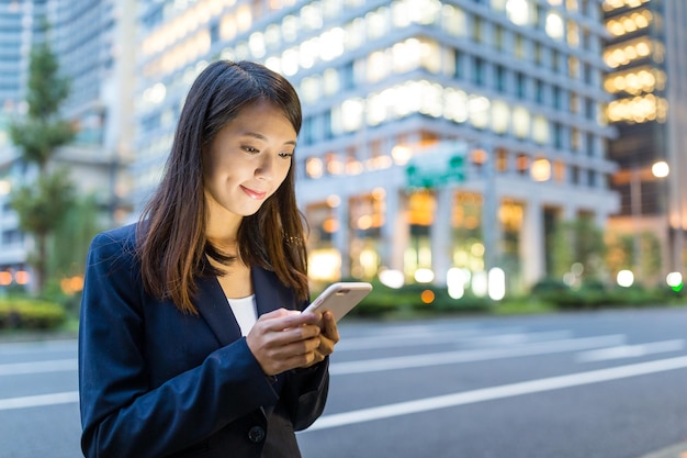 Geschäftsfrau, die am Handy in der Stadt Tokio arbeitet