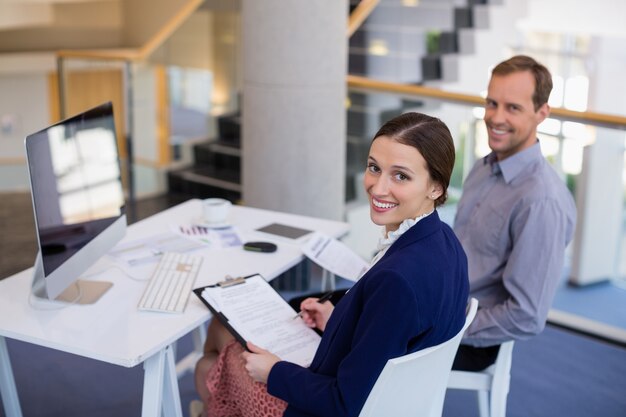 Geschäftsfrau, die am Schreibtisch mit Kollege arbeitet