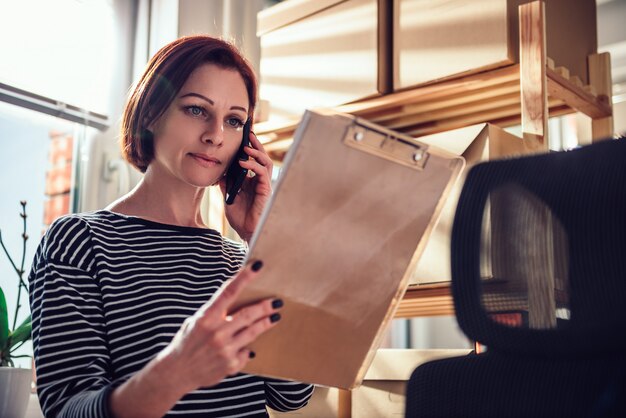 Geschäftsfrau, die am Telefon im Büro spricht