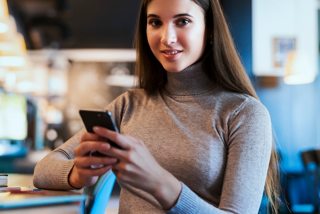 Geschäftsfrau, die am Tisch sitzt und am Projekt arbeitet. Junge Frau, die digitale Geräte für Arbeit verwendet.