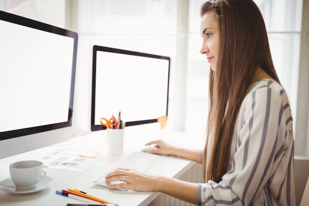 Geschäftsfrau, die an Computer im Büro arbeitet