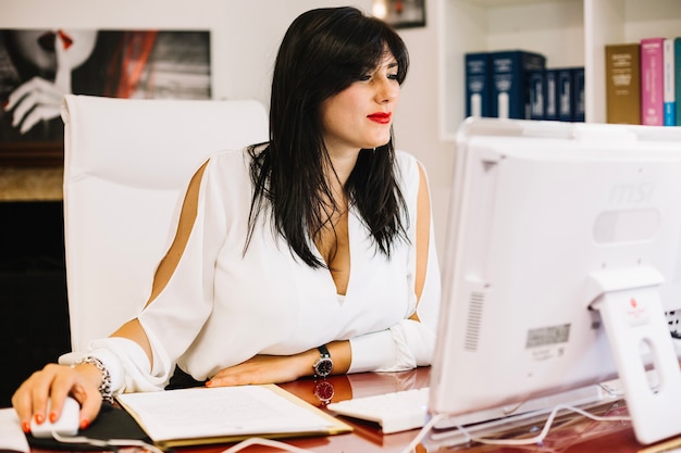 Geschäftsfrau, die an Computer im stilvollen Büro arbeitet