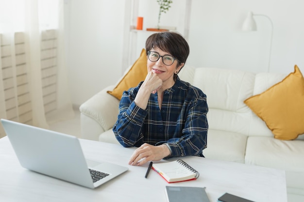 Geschäftsfrau, die an einem Laptop arbeitet, sitzt zu Hause in Pyjama-Heimkleidung und verwaltet ihr Geschäft über Home Office während der Quarantäne von Coronavirus oder Covid19