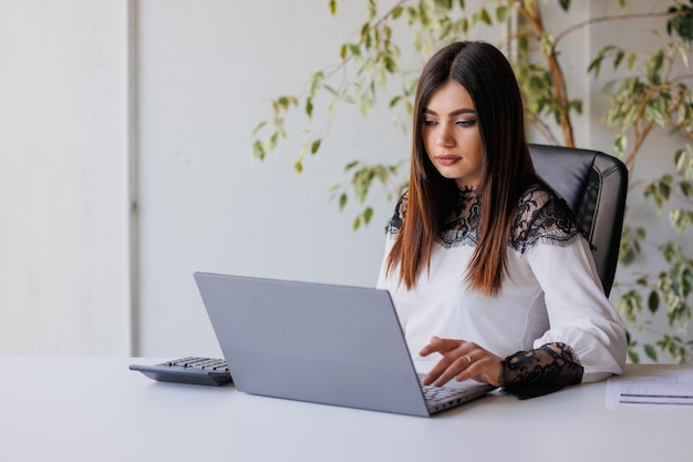 Geschäftsfrau, die an einem Laptop im Büro arbeitet