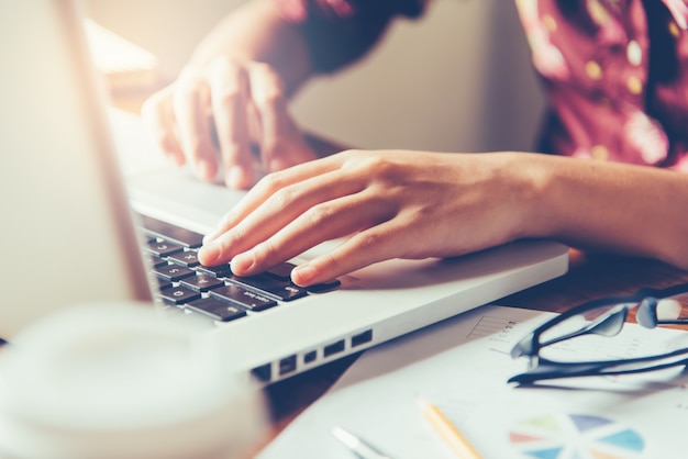 Foto geschäftsfrau, die an laptop-computer im büro arbeitet