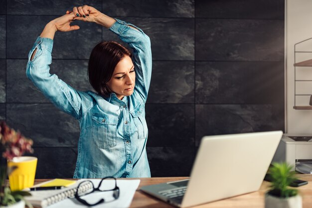 Foto geschäftsfrau, die arme im büro ausdehnt