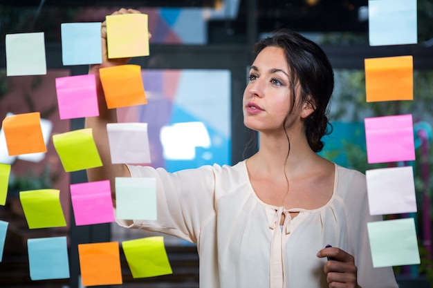 Geschäftsfrau, die ein Post-It verschiebt