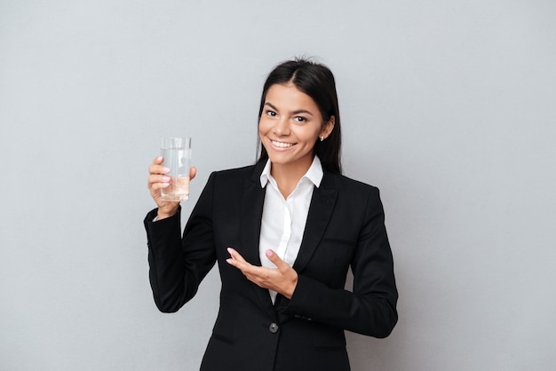 Geschäftsfrau, die Glas Mineralwasser in ihrer Hand zeigt