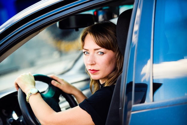 Geschäftsfrau, die ihr Auto fährt.