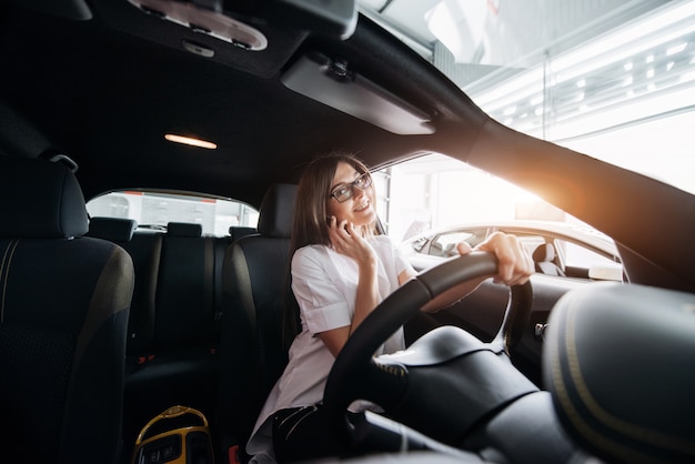 Geschäftsfrau, die im Auto am Telefon spricht