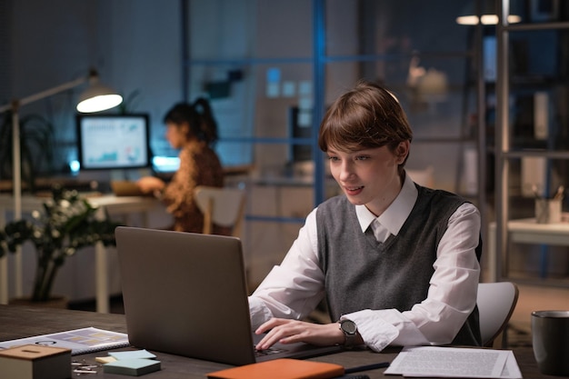 Geschäftsfrau, die im Büro am Laptop arbeitet