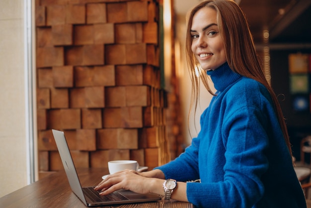 Geschäftsfrau, die in einem Café am Laptop arbeitet