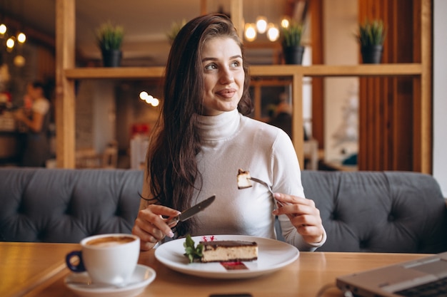 Geschäftsfrau, die in einem Café arbeitet und isst