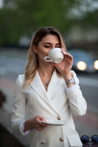 Geschäftsfrau, die Kaffee auf der Straße trinkt