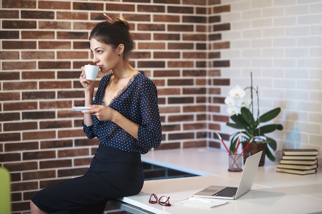 Geschäftsfrau, die Kaffee im Büro trinkt